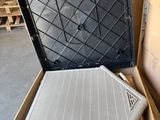 une boîte contenant un ordinateur portable, posée par terre