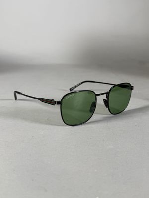 des lunettes de soleil posées sur une surface blanche, avec un mur blanc en arrière-plan