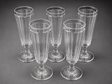 four clear wine glasses sitting on top of a table