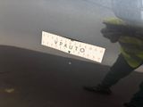 a man standing next to a car with a sticker on it
