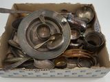 une boîte remplie de cuillères en argent et des cuillères posées sur une table