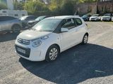 a small white car parked in a parking lot