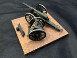 a small model of a cannon on a wooden board