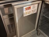 stainless steel counter top with dishwasher and dish rack in a commercial kitchen