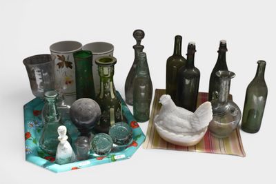 many glass bottles and vases sitting on a table