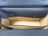 the inside of a blue purse with a black handle