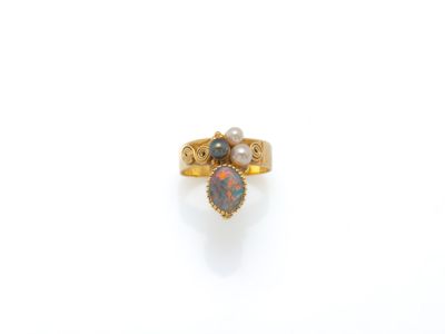un gros plan d'une bague en or sertie d'un oplite et d'une perle