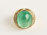 une bague en or sertie d'une pierre verte entourée de diamants