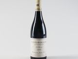 the bottle of wine is sitting on a white surface