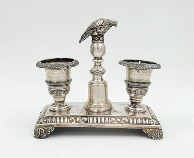 une image représentant un plateau en argent sur lequel sont posées deux bougies et un oiseau