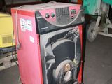 a red machine sitting on a pallet in a garage