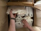 un homme tenant du courrier dans une boîte aux lettres