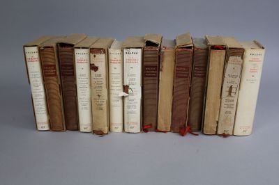 several old books are lined up in a row on a gray surface