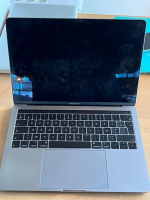 an open laptop computer sitting on top of a wooden desk