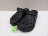 a pair of black crocs on a white table