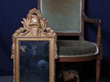 une chaise sur laquelle est posé un miroir, à côté d'une autre chaise