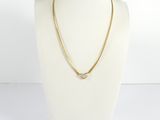 un collier à chaîne en or avec un fermoir en diamant, porté par un mannequin