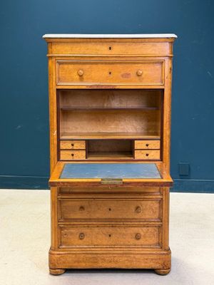 an old wooden desk with a blue top and drawers
