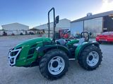 un tracteur vert garé devant un bâtiment