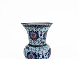 a blue and red vase sitting on a white surface