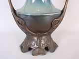 a blue and silver vase sitting on a stand