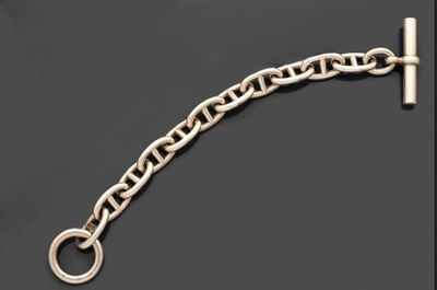 un gros plan d'un bracelet à chaîne argentée sur fond noir