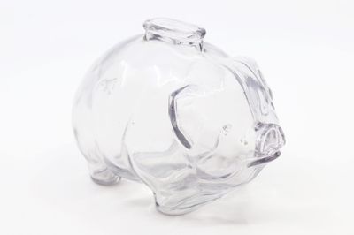 une figurine en verre représentant un cochon, posée sur une surface blanche