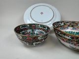 two bowls and a plate sitting on a table with a plate in the background