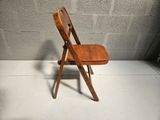 a wooden chair that is sitting on a cement floor