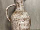 un vase blanc posé sur une étagère en verre dans une pièce