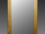 un grand miroir ancien dans un cadre doré, sur fond noir