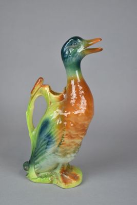 un petit canard en céramique posé sur une table