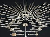 de nombreuses fourchettes et cuillères disposées en forme de rayons de soleil