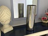 a vase on a table with a mirror in the background