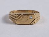 a close up of a gold ring with a diamond on it
