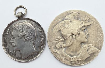 une vieille pièce et une pièce en argent à l'effigie d'une femme