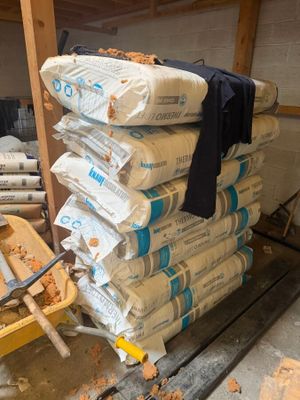 une pile de sacs de ciment posée sur une charrette en bois