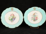 two plates with floral designs on them on a black background