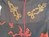 a black dress with a red and orange design on it