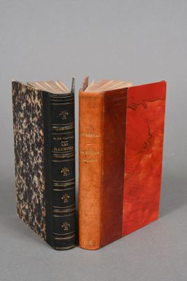 two old books sitting next to each other on a gray surface
