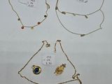 three necklaces and a bracelet are shown on a white surface
