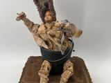 an image of a statue of a man sitting in a bucket