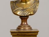 paire de bustes de femmes en bronze posés sur des socles, disposés sur une table en bois