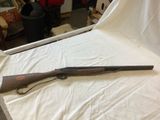 a gun that is laying on a bed in a room