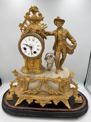 a statue of a man holding a clock on top of a table