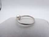 a close up of a ring with a pearl on top of it