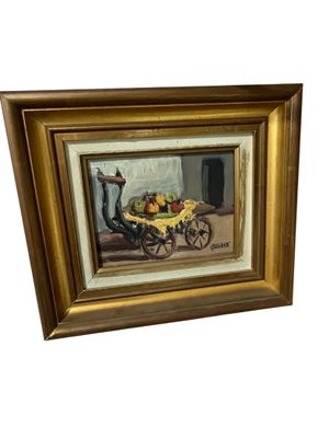 tableau représentant un chariot rempli de fruits posé sur une table en bois