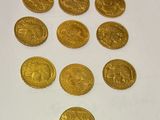a close up of a bunch of gold coins on a white surface
