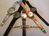 plusieurs montres de différentes couleurs empilées les unes sur les autres sur une table