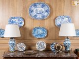 de nombreuses assiettes et lampes bleues et blanches posées sur une table